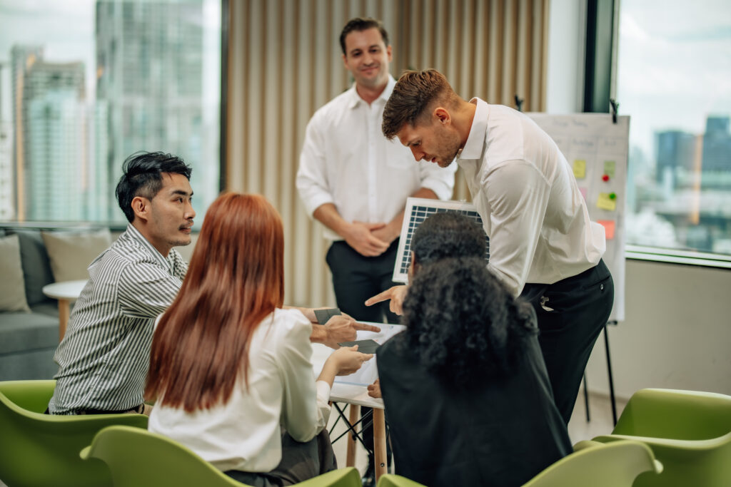 Diverse leadership team in Singapore engaged in an interactive coaching workshop led by a seasoned corporate training provider