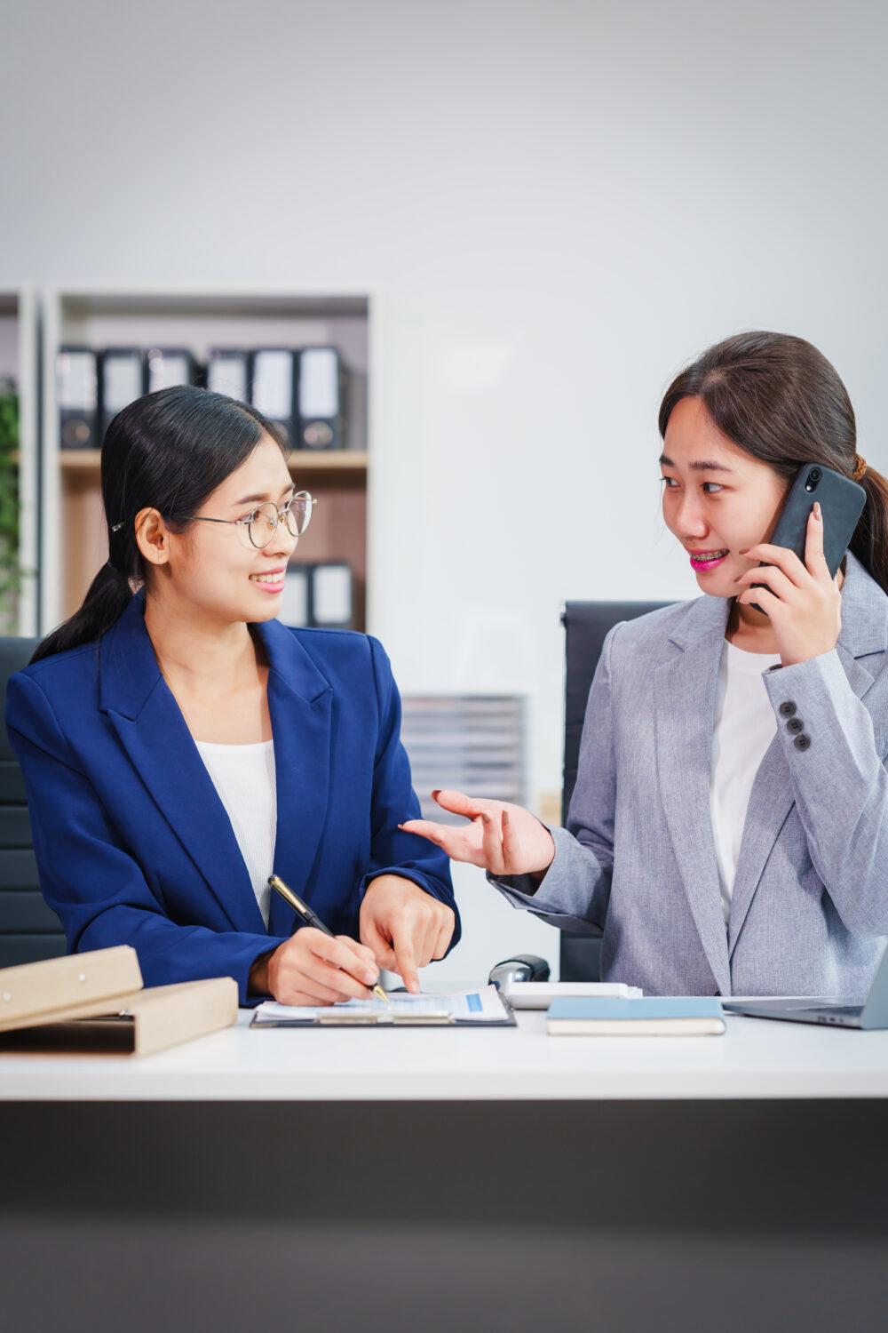 A business consultant reviewing performance metrics with clients in a Singapore office.