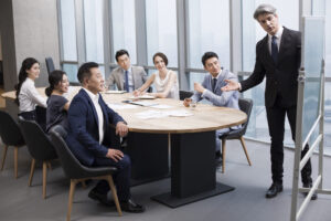 A group photo of executives and coaches smiling together at the end of a successful program in Singapore