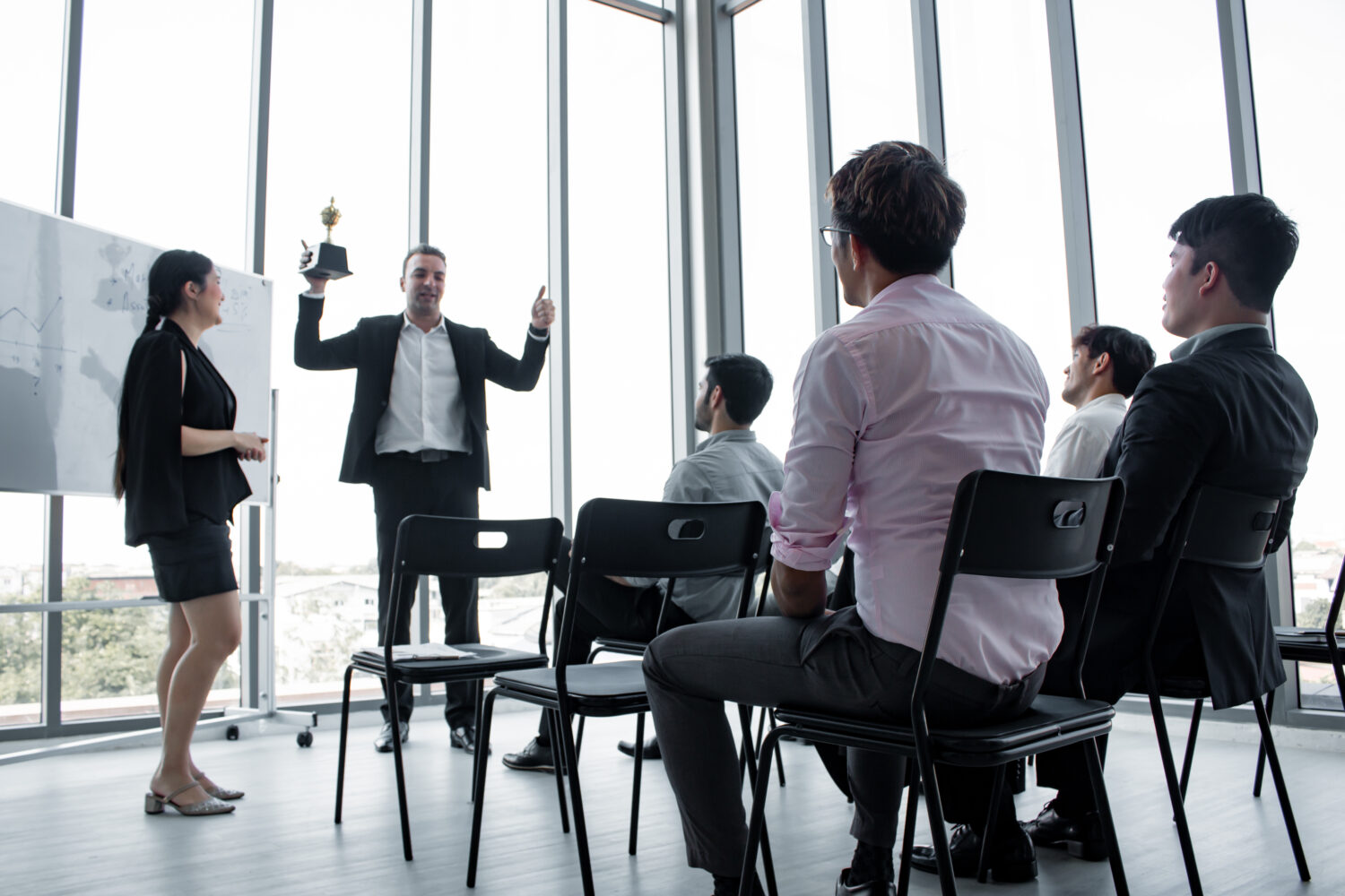 Corporate training session in a modern conference room in Singapore, with employees taking notes