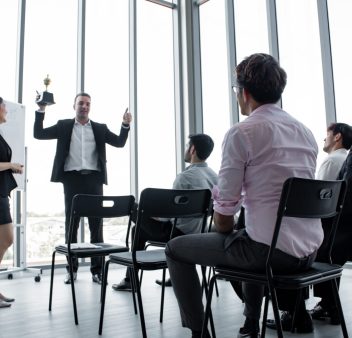 Corporate training session in a modern conference room in Singapore, with employees taking notes